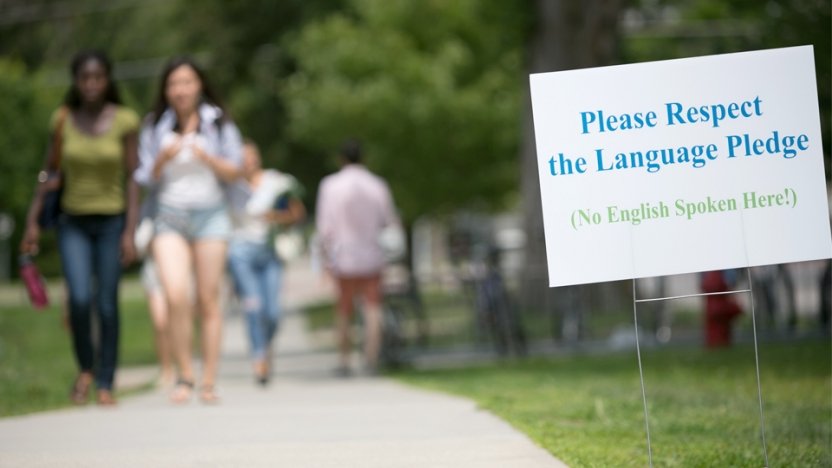 A sign that reads "Please respect the language pledge (No English spoken here!)"
